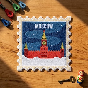 May include: A square embroidered patch shaped like a postage stamp featuring a red Kremlin-style building with a green roof and clock tower against a dark blue sky with white snow. The word MOSCOW is stitched in white at the top of the patch.