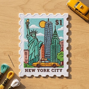 May include: A rectangular embroidered patch shaped like a postage stamp featuring the Statue of Liberty, the One World Trade Center, the Chrysler Building, and a yellow taxi. The text $1 and NEW YORK CITY are stitched in brown thread.