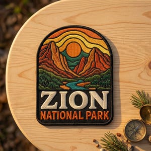 May include: An embroidered patch featuring a landscape of Zion National Park with red rock mountains, a blue river, and a yellow sun against an orange sky. The text ZION NATIONAL PARK is stitched in white and orange on a black background.