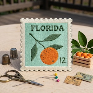 May include: A square embroidered patch shaped like a postage stamp with a light green background, featuring a dark green leafy orange branch, the text FLORIDA, and the number 12. The border is cream-colored with a scalloped edge design.