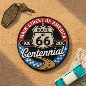May include: A circular embroidered patch featuring the text Main Street of America, Route US 66, 1926, 2026, and Centennial. The design includes a shield emblem, a winding road, and a checkered border in red, white, blue, black, and gold thread.