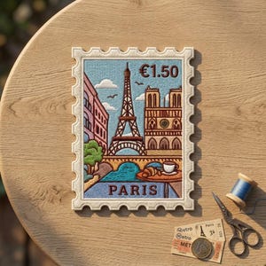 May include: A rectangular embroidered patch shaped like a postage stamp featuring a scene of Paris with the Eiffel Tower, Notre Dame, a croissant, and a coffee cup. The text "€1.50" and "PARIS" are stitched in brown thread on a light blue background.