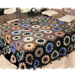 Peut inclure: Une couvre-lit en crochet avec un fond brun et un motif de fleurs colorées. La couvre-lit est sur un lit avec deux oreillers.