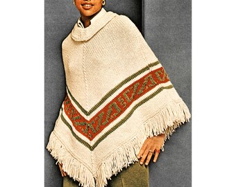Op de afbeelding: Een witte gebreide poncho met een rood, groen en wit gestreept patroon en franjes. De poncho heeft een rolkraag en wordt gedragen door een persoon met een rode baret.