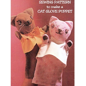 以下が含まれることがあります： 猫の手袋人形を作るための縫製パターン。パターンには、茶色とピンクの2匹の猫が描かれており、白いシャツとピンクのスカートを着ています。