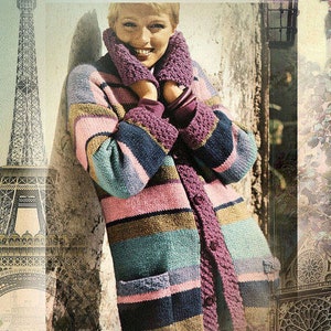 May include: A woman wearing a striped cardigan with a pink, blue, and brown color scheme. The cardigan has a long, loose fit and features a pocket on the left side. The woman is standing in front of a vintage-style background with a view of the Eiffel Tower.