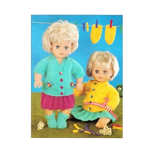 May include: Two dolls wearing knitted outfits. The doll on the left is wearing a turquoise cardigan with pink buttons, a pink skirt, and turquoise socks. The doll on the right is wearing a yellow cardigan with pink buttons and a turquoise skirt.