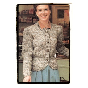 May include: A brown and white knit cardigan with a button-up front and a collar. The cardigan is worn over a blue skirt.