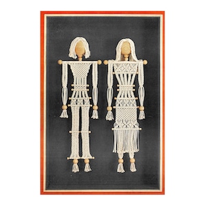 May include: Two macrame figures, a man and a woman, are hanging in a black frame with a red border. The figures are made of white string and have wooden heads and arms.