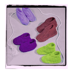 May include: Six pairs of knitted slippers in various colors, including purple, green, and brown. The slippers are laid out on a light gray surface.