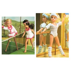 May include: Two dolls wearing knitted outfits. One doll is wearing a white tennis dress with pink trim and a white cardigan with pink trim. She is holding a tennis racket and is standing on a tennis court. The other doll is wearing a blue leotard and blue leg warmers. She is holding a ballet barre.