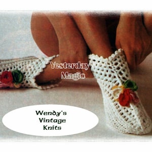 May include: White crocheted slippers with floral embellishments. The slippers feature an openwork pattern and are adorned with small, colourful flowers. The text "Yesterday Magic" and "Wendy's Vintage Knits" are also visible.