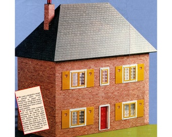 Op de afbeelding: Een rood bakstenen poppenhuis met een grijs dak van shingles. Het huis heeft vijf ramen met gele luiken en hartvormige uitsnijdingen. De voordeur is rood. De tekst op het papier luidt: "We hebben een heerlijk assortiment speciaal papier gebruikt om onze kamers te behangen. Probeer dun inpakpapier te gebruiken om te behangen terwijl je je tijd besteedt aan een klein patroon."
