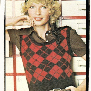 May include: A woman wearing a red and black diamond patterned knitted vest with a brown shirt underneath. She is wearing a black belt with silver eyelets and a black headband.
