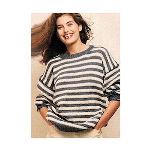 May include: A woman wearing a blue and white striped sweater with long sleeves. The sweater has a relaxed fit and a round neckline.