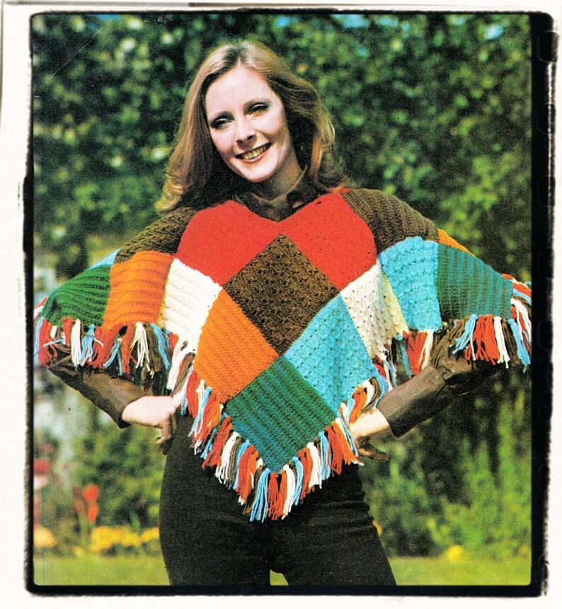 May include: A colorful crocheted poncho with fringe. The poncho is made of different colored squares in red, orange, green, blue, white, and brown.