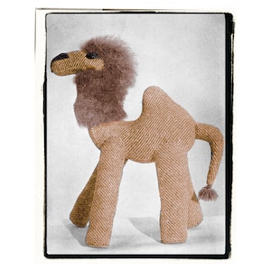 May include: A brown and tan knitted camel toy with a furry head and a long tail. The toy is standing on a white surface.