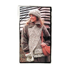 May include: A woman wearing a brown and white knit hat and scarf with a brown jacket and a brown leather bag.