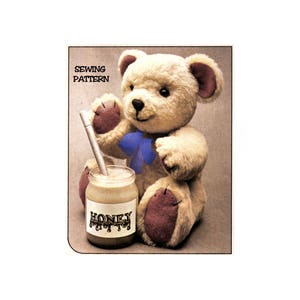 May include: A sewing pattern for a teddy bear with a blue bow and a jar of honey. The pattern is titled "Sewing Pattern".