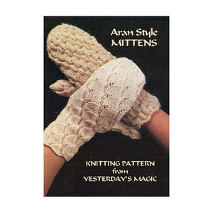 May include: A pair of white knitted mittens with an Aran style pattern. The knitting pattern is from Yesterday's Magic.