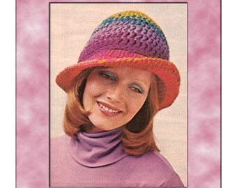 May include: Crochet pattern to make a rainbow hat. The hat is a bright pink, yellow, green, and blue color. The hat is worn by a woman with long brown hair.