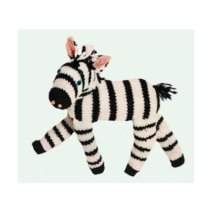 May include: A black and white striped knitted zebra toy. The zebra has pink ears and blue eyes.