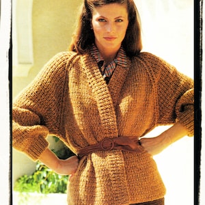 May include: A brown knitted cardigan with a shawl collar and a brown leather belt. The cardigan is open in the front and has long sleeves.