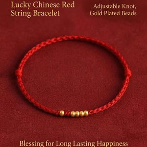 May include: A red string bracelet with gold-plated beads. The bracelet features an adjustable knot and is described as a "Lucky Chinese Red String Bracelet". The text also mentions "Blessing for Long Lasting Happiness".