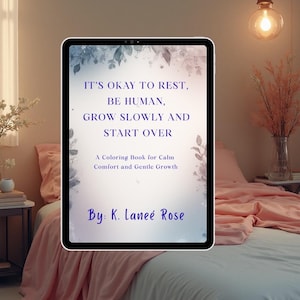 May include: A digital tablet displays the text "IT'S OKAY TO REST, BE HUMAN, GROW SLOWLY AND START OVER." The text is from a coloring book for calm, comfort, and gentle growth, by K. Laneé Rose. The tablet is on a bed with pink bedding.