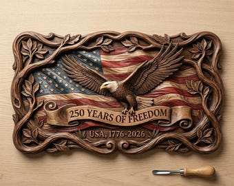 Puede incluir: Un relieve rectangular de madera que muestra un águila calva en vuelo sobre una bandera estadounidense ondeante. Una cinta central dice 250 YEARS OF FREEDOM y USA, 1776-2026. El diseño está enmarcado por ramas y hojas talladas intrincadas.
