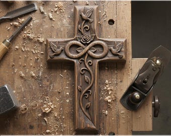May include: A carved wooden cross with intricate details, including doves, a rose, and an infinity symbol. The cross is brown and sits on a wooden surface. Text at the top reads "CNC & 3D PRINT READY" and at the bottom "Decorative Cross STL".
