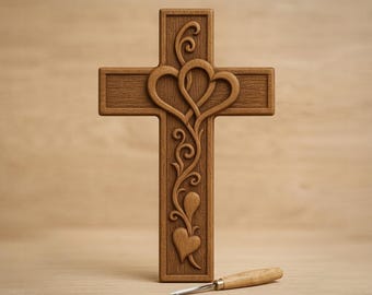 May include: A wooden cross with a carved design featuring two intertwined hearts and floral accents. The cross is brown and has a detailed, textured surface. The text "CNC & 3D PRINT READY" and "Cross 3D STL" are visible. A carving tool rests below the cross.
