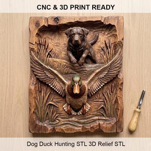 Op de afbeelding: Een houten reliëf met een Labrador Retriever en een vliegende eend. De hond staat boven de eend, met riet en waterdetails. De tekst "CNC & 3D PRINT READY" en "Dog Duck Hunting STL 3D Relief STL" zijn zichtbaar.