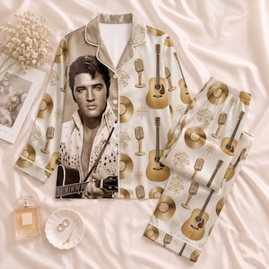 Puede incluir: Un conjunto de pijama de dos piezas en color crema con un patrón repetitivo de guitarras acústicas doradas, micrófonos vintage y discos de vinilo. La camisa de manga larga con botones muestra un gran retrato de Elvis Presley tocando.