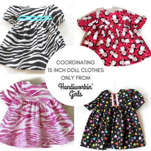 May include: Four doll dresses in different patterns. One has a black and white zebra print with a turquoise stripe. Another is red with penguin graphics. A third is pink zebra print, and the last is black with colourful hearts. Text reads: "COORDINATING 15 INCH DOLL CLOTHES ONLY FROM Handiworkin' Girls."