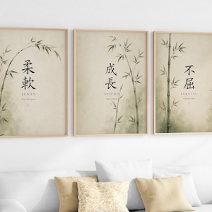 以下が含まれることがあります： ベージュの背景に水彩画風の竹が描かれた、3枚セットの額入りウォールアート。各プリントには日本語の漢字、ローマ字表記、そしてBend with grace、Open growth、Unbroken spiritという英語のフレーズが記されています。