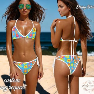 May include: A two-piece string bikini with a floral pattern. The bikini top and bottom are light blue with a white trim and a pattern of colorful flowers. The words "custom any request" are printed on the bottom left.