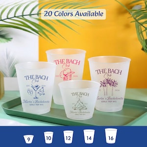 Puede incluir: Cuatro vasos de pl&aacute;stico esmerilado de varios tama&ntilde;os, impresos con 'THE BACH Club' y 'Martin's Bachelorette'. Los dise&ntilde;os incluyen un c&oacute;ctel, un sombrero de vaquero, una fogata y palmeras. Una etiqueta superior dice '20 Colors Available'.