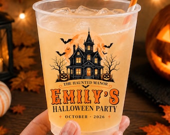 May include: A clear plastic party cup filled with a light orange beverage and ice, featuring a black graphic of a haunted manor, bats, and pumpkins. The text reads: THE HAUNTED MANOR EMILY'S HALLOWEEN PARTY OCTOBER 2026. An orange and white striped straw is included.