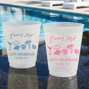 May include: Two frosted plastic cups featuring beach-themed graphics including a cocktail, umbrella, lounge chair, seashell, and palm trees. The text reads Emma's 21st, LET'S CELEBRATE, and MIAMI 2025, printed in blue on one cup and pink on the other.
