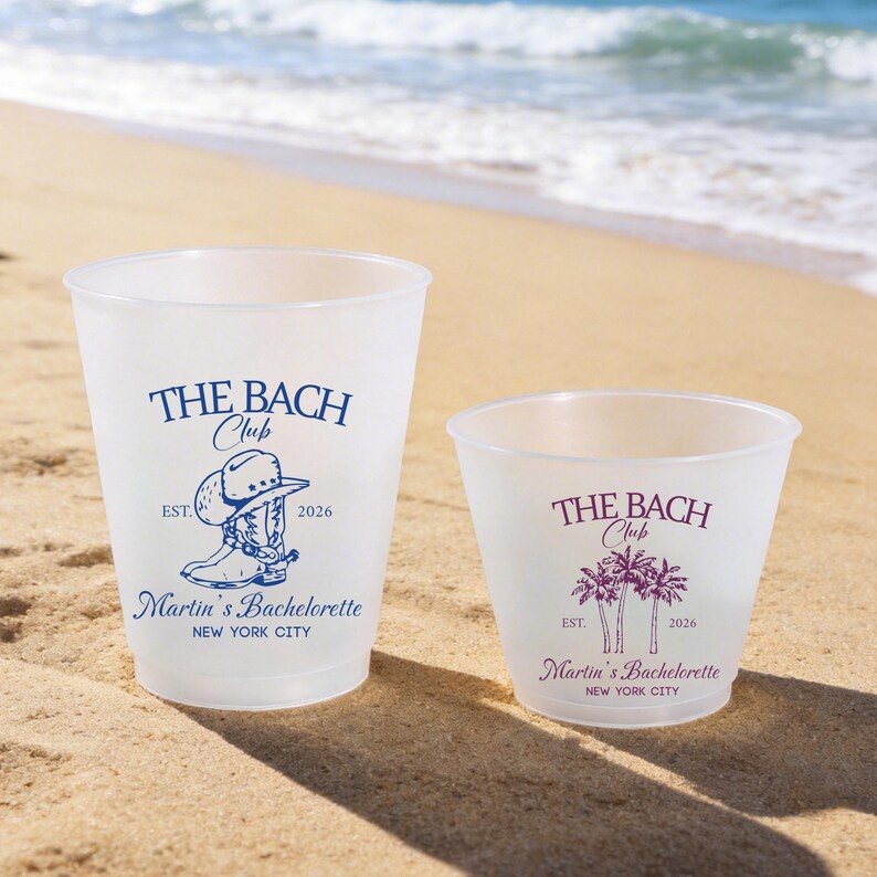 Puede incluir: Dos vasos de pl&aacute;stico esmerilado con texto y gr&aacute;ficos en azul y morado. El vaso grande muestra una bota vaquera y el texto THE BACH CLUB EST. 2026 Martin's Bachelorette NEW YORK CITY. El vaso peque&ntilde;o muestra palmeras y el mismo texto.