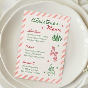 May include: A Christmas menu card with a festive design. The card features a white background with diagonal pink stripes and green and red text. The menu includes starters, mains, and dessert options, with illustrations of ornaments, champagne flutes, and a cake.