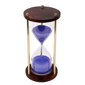May include: An hourglass with a dark brown wooden top and base, connected by gold-coloured metal rods. The hourglass contains blue sand within a clear glass chamber. Decorative gold-coloured accents are on the top.