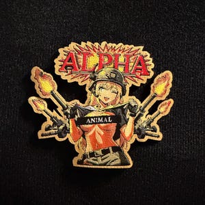 May include: An embroidered patch featuring an anime-style character wearing a helmet and tactical gear, winking while holding a black banner with the word ANIMAL. Above the character, the word ALPHA is displayed in red letters with a burst design.