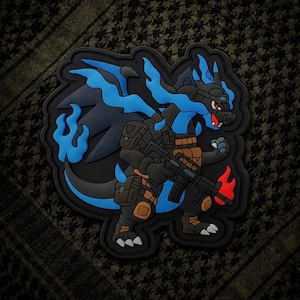 May include: A black and blue dragon patch with a military theme. The dragon is holding a rifle and has blue flames. The patch has a black border and is set against a green and black patterned background.