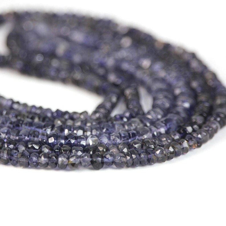 May include: A strand of dark blue faceted gemstone beads. The beads are small and have a slightly irregular shape.