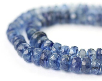May include: A strand of blue gemstone beads, faceted and with a slightly irregular shape. The beads are strung together to create a necklace or bracelet.