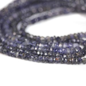 May include: A strand of dark blue faceted gemstone beads. The beads are small and have a slightly irregular shape.