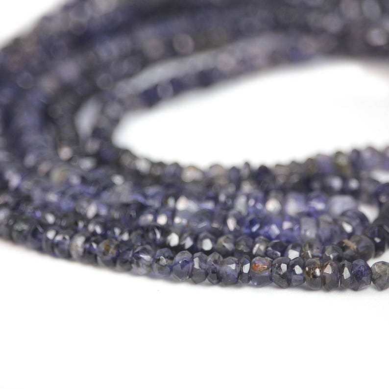 May include: A strand of dark blue faceted gemstone beads. The beads are small and have a slightly irregular shape.