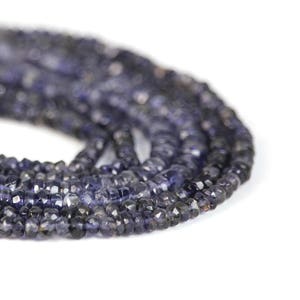 May include: A strand of dark blue faceted gemstone beads. The beads are small and have a slightly irregular shape.